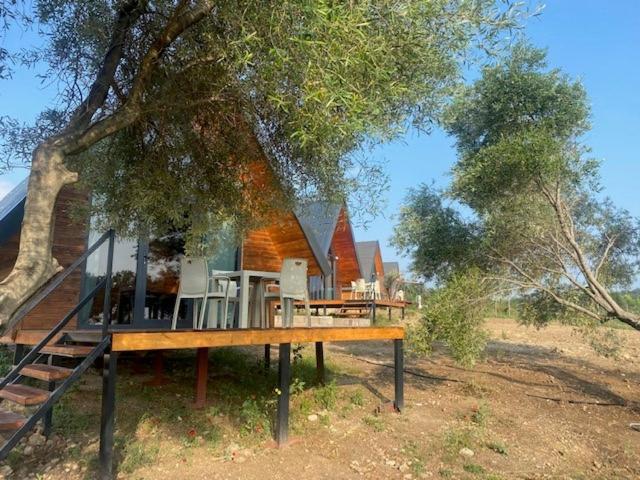 a house with a deck next to a tree at NefesURLA Bungalov4 in Urla