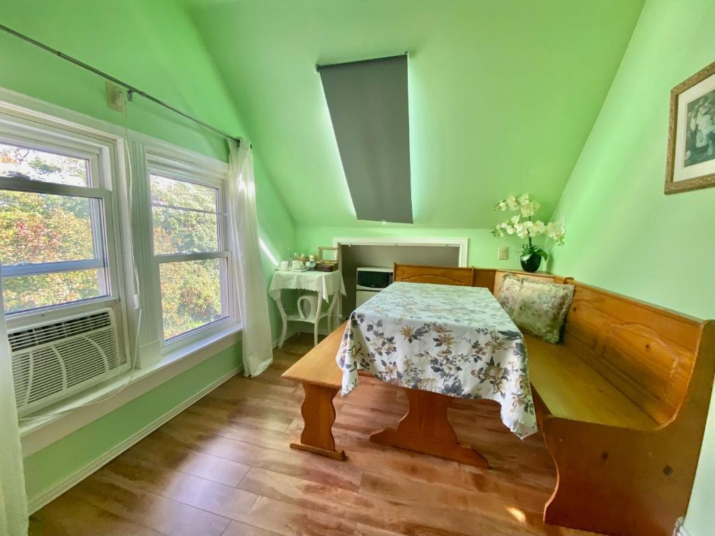 une chambre verte avec une table et une fenêtre dans l'établissement Cozy 1-bedroom loft with falls view 4mins to falls, à Niagara Falls