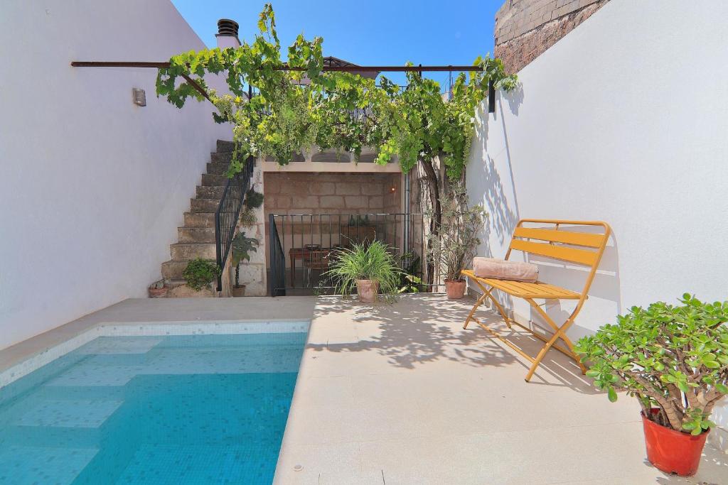 a patio with a pool and a chair next to a house at Es Colomer 265 by Mallorca Charme in Muro