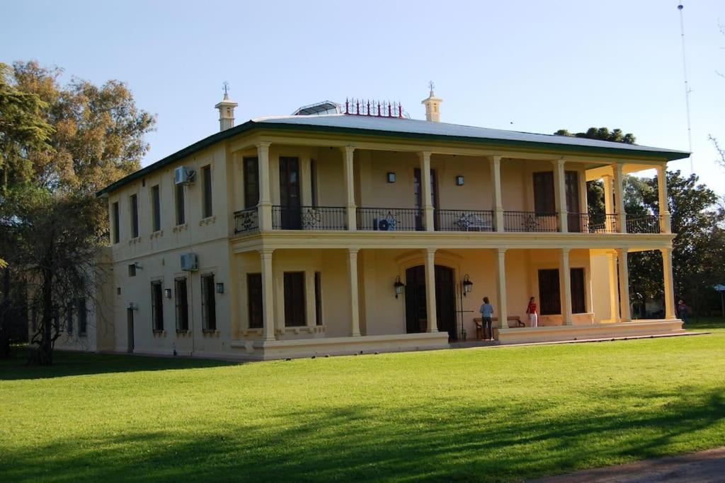 a large white house with a large grass field at Casco histórico de Estancia in Monte Buey