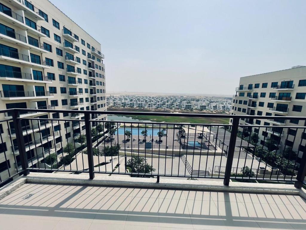a balcony of a building with a view of a city at Emaar South - Two Bedroom Apartment with Pool and Golf Course View in Dubai