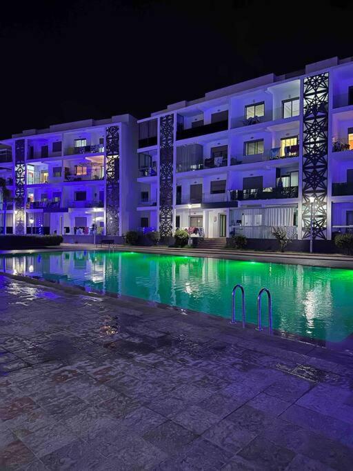 a large building with a swimming pool at night at Les perles de mimosa Mohammédia in Mohammedia