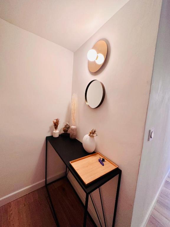 a small table with a mirror on a wall at L&#39;Etoile - Duplex cosy de 50m2 en centre-ville in Nîmes