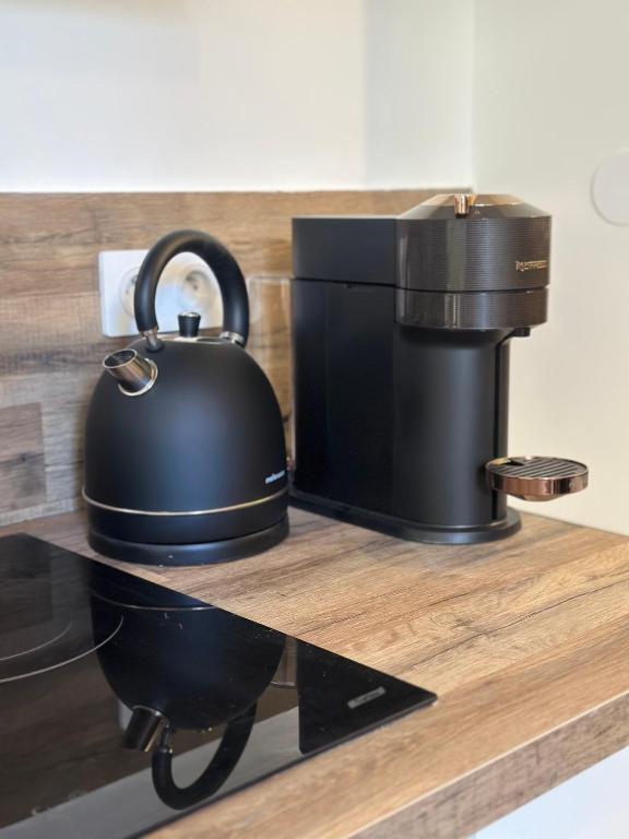 a tea kettle sitting on a counter next to a coffee maker at L&#39;Etoile - Duplex cosy de 50m2 en centre-ville in Nîmes