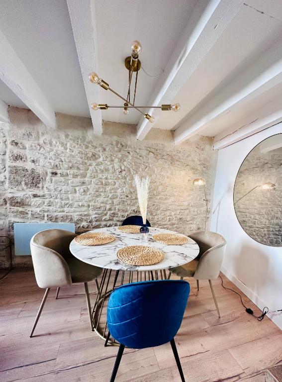 a dining room with a table and chairs at L&#39;Etoile - Duplex cosy de 50m2 en centre-ville in Nîmes