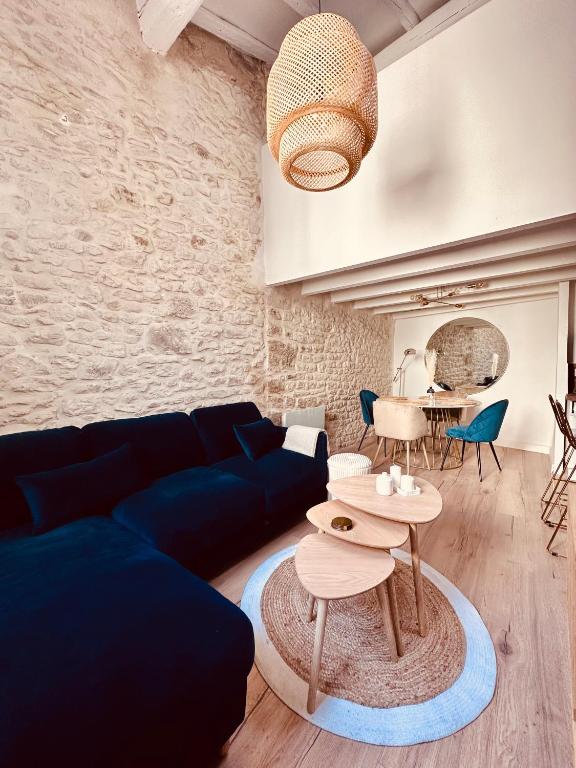 a living room with a blue couch and a table at L&#39;Etoile - Duplex cosy de 50m2 en centre-ville in Nîmes