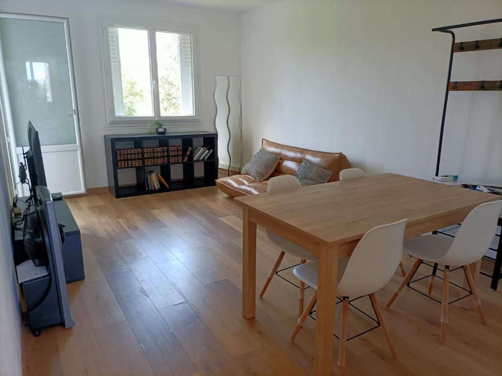 sala de estar con mesa de madera y sillas en Appartement spacieux et bien équipé Hôpitaux Facultés en Montpellier