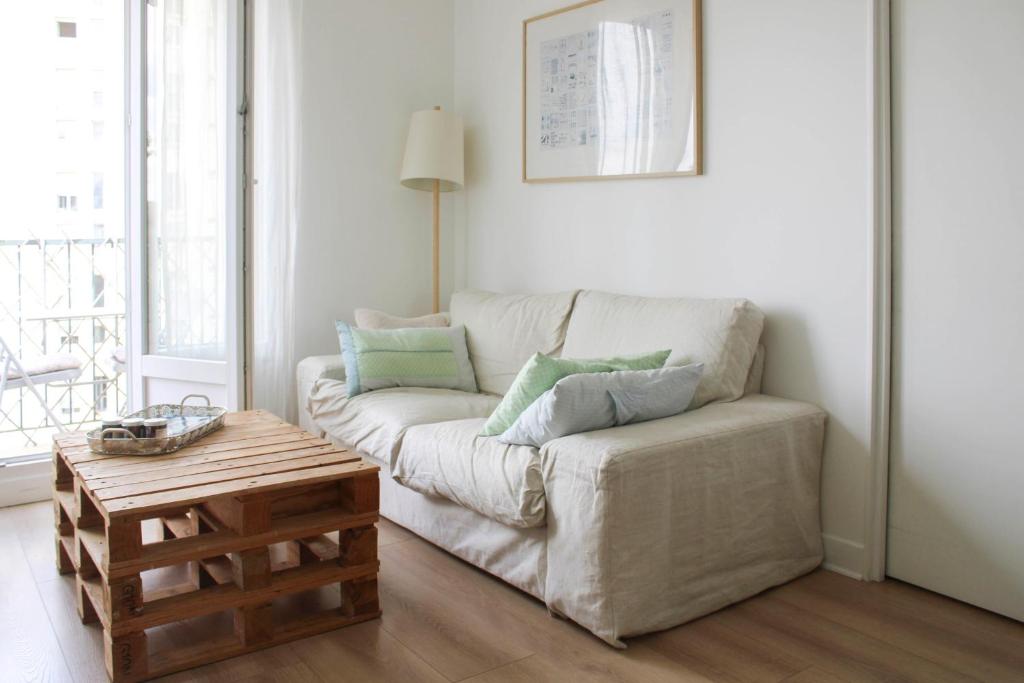 un salon avec un canapé et une table basse dans l'établissement Through apartment - Place de la Réunion, à Paris