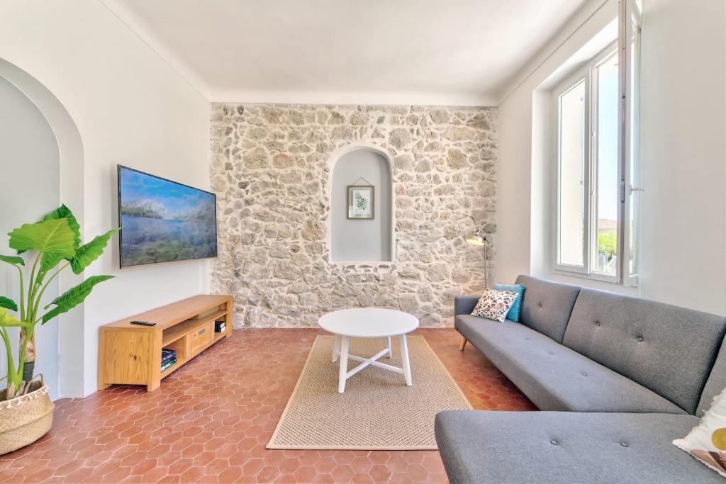 a living room with a couch and a table at Maison Sara Juan les Pins in Juan-les-Pins