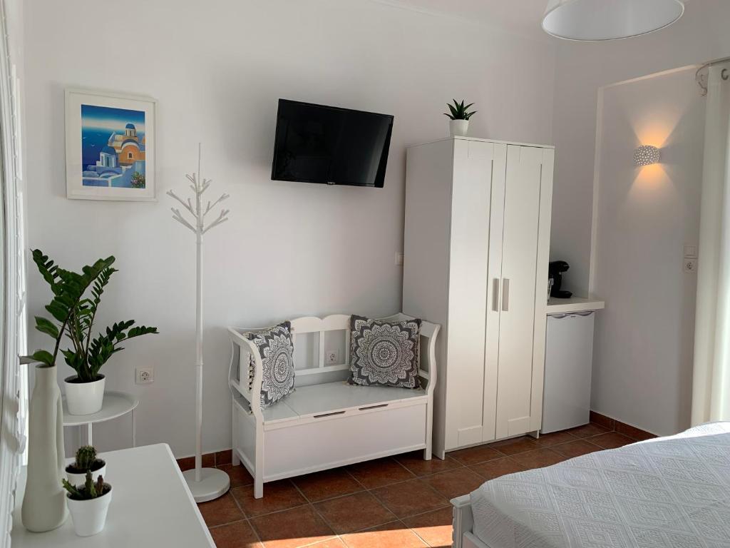 1 dormitorio con armario blanco y TV en la pared en Sea and Salt Naxos 1, en Kastraki Naxou