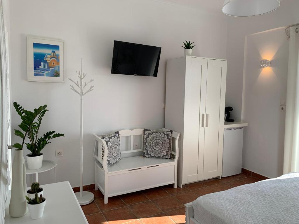 a bedroom with a white cabinet with a tv on the wall at Sea and Salt Naxos 1 in Kastraki Naxou