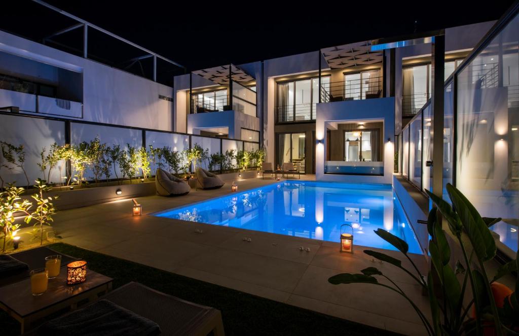 a house with a swimming pool at night at Cretan Queen Residences in Aghii Apostoli