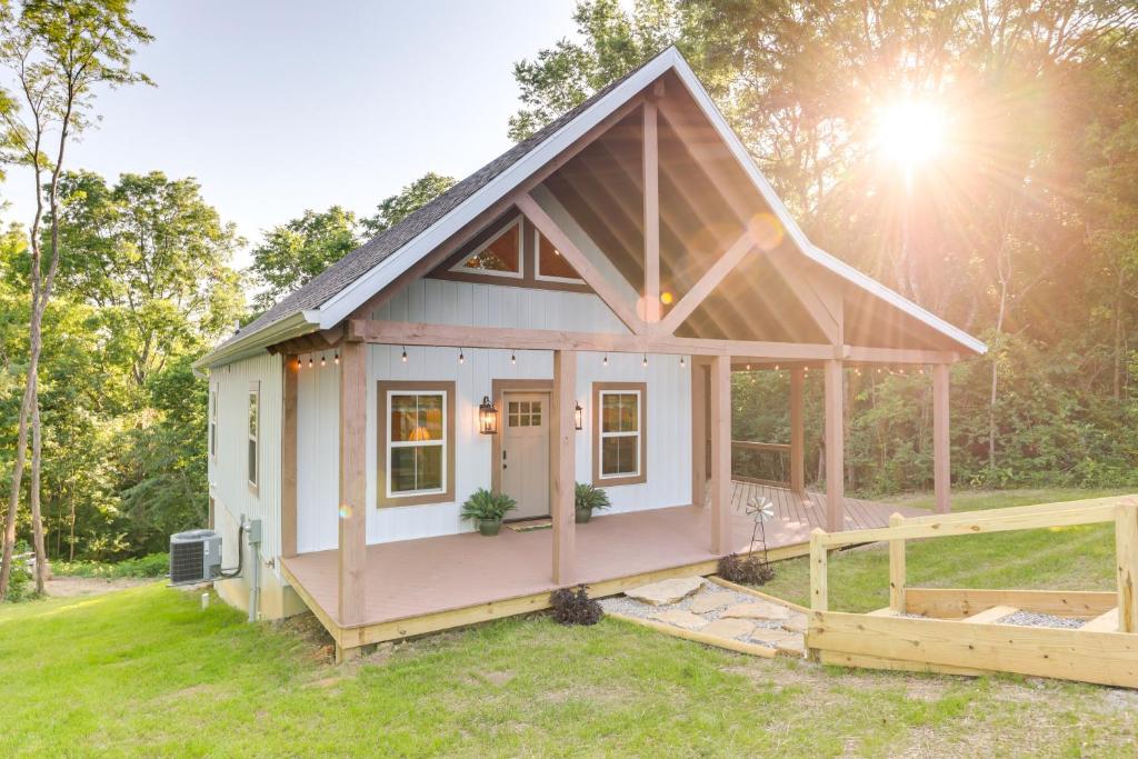 a tiny house in a field with the sun in the background at Serene Kentucky Cabin with Fireplace and Fire Pit! in Williamstown
