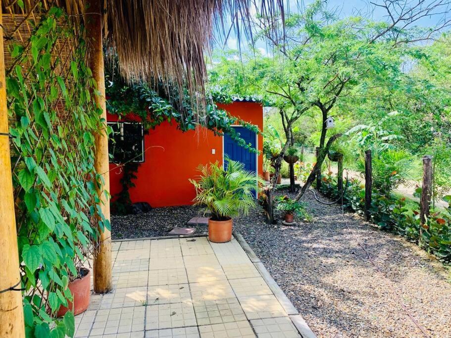 a house with an orange wall and some plants at Mini Casa Campestre Privada in La Playa