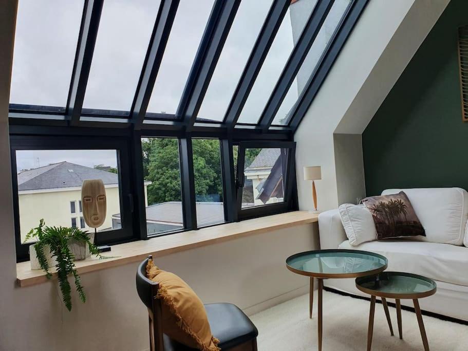 a living room with a couch and a window at Sous les toits de Saint-Félix in Nantes