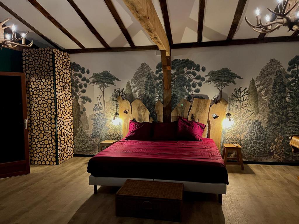 Schlafzimmer mit einem Bett mit roter Bettwäsche und Bäumen an der Wand in der Unterkunft La cabane de babarot in Aups