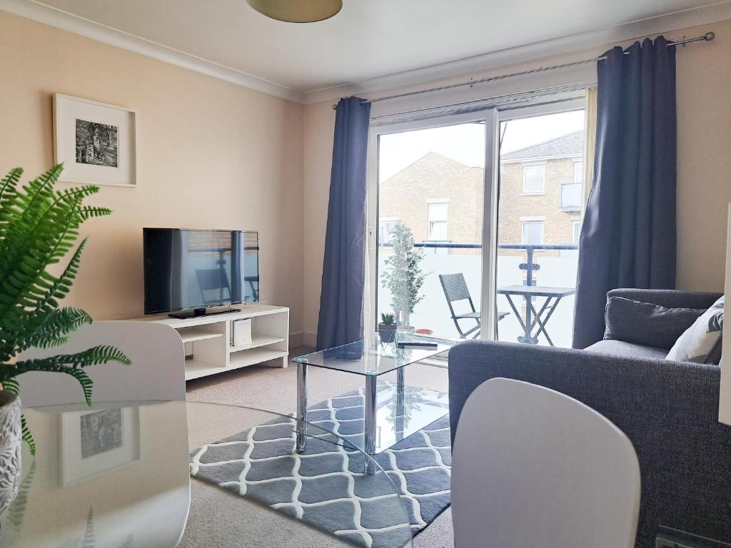 a living room with a couch and a tv at Wimbledon Apartment in London