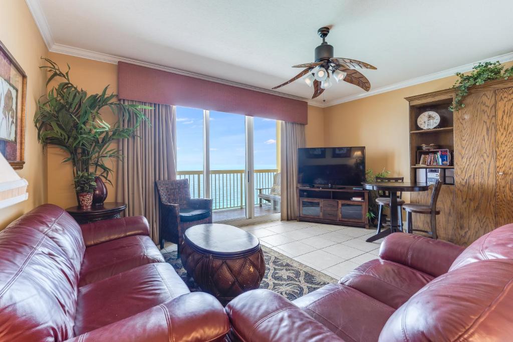 a living room with a leather couch and a television at Calypso Resort Serenity 1 in Panama City Beach
