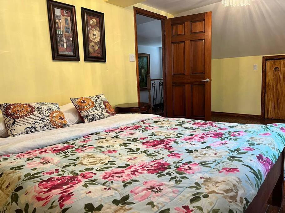 1 dormitorio con 1 cama con colcha de flores en Petite maison 2 bedrooms en Lévis
