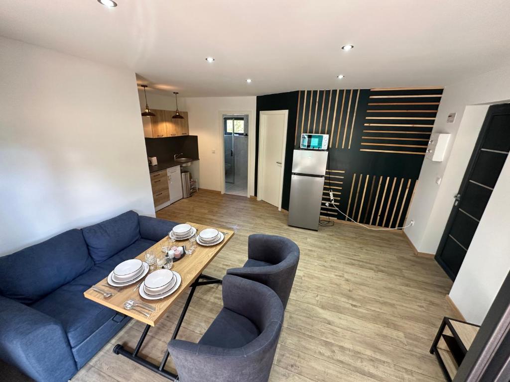 un salon avec un canapé bleu et une table dans l'établissement Cour ancienne école avec Jacuzzi privé, à Gérardmer