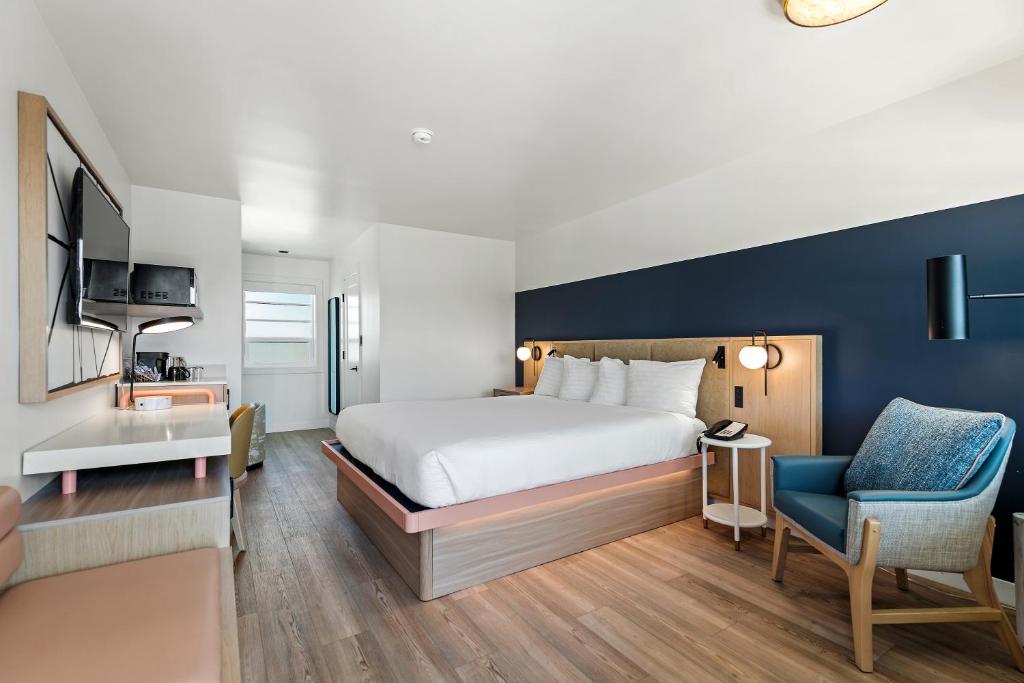 a hotel room with a bed and a blue accent wall at Chablis Inn in Napa