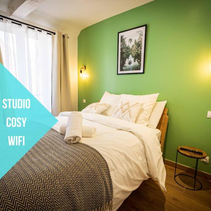 - une chambre dotée d'un lit avec un mur vert dans l'établissement L'Albatros 002 - Hypercentre * Cosy * Wifi, à Saint-Quentin