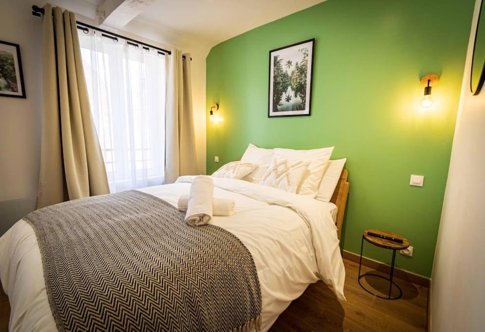 - une chambre avec un mur vert et un lit dans l'établissement L'Albatros 002 - Hypercentre * Cosy * Wifi, à Saint-Quentin