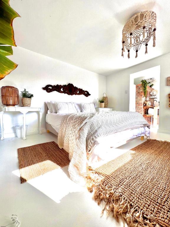 a bedroom with a large bed and a rug at Sunny Bali Cottage in Mossel Bay