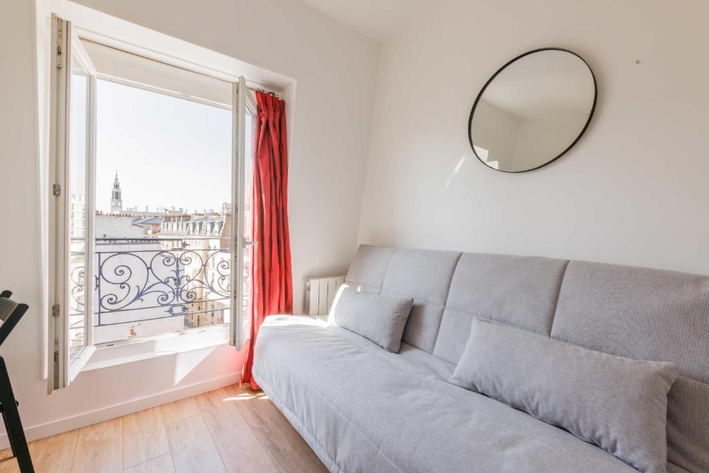 un salon avec un canapé et une grande fenêtre dans l'établissement Studio confortable - 2P - Proche Nation, à Paris