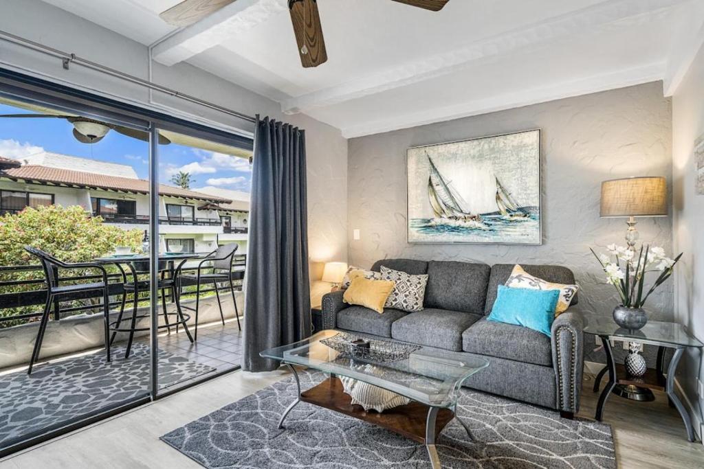 a living room with a couch and a glass table at Casa de Emdeko 221 in Kailua-Kona