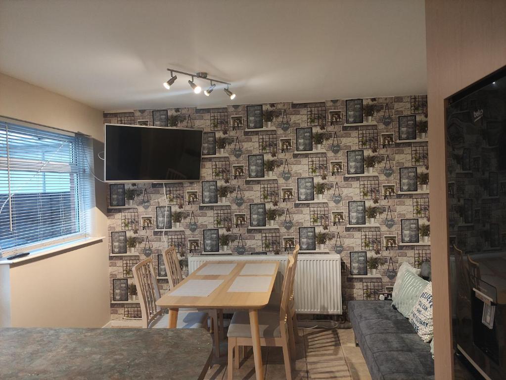 a dining room with a table and a wall covered in photographs at Perfect Place in Walsall/ 4 bedroom / long term workers or family home in Walsall