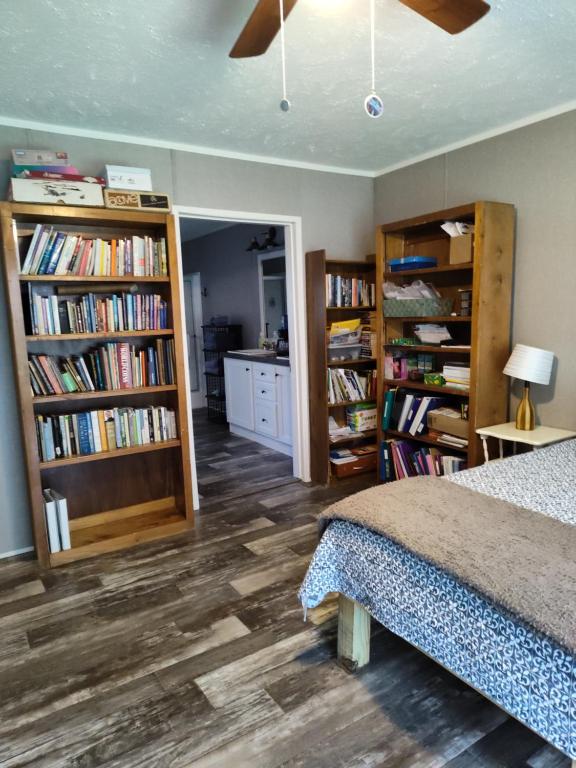 ein Schlafzimmer mit einem Bett und Bücherregalen mit Büchern in der Unterkunft Riley's Pad Master Suite in Sevierville