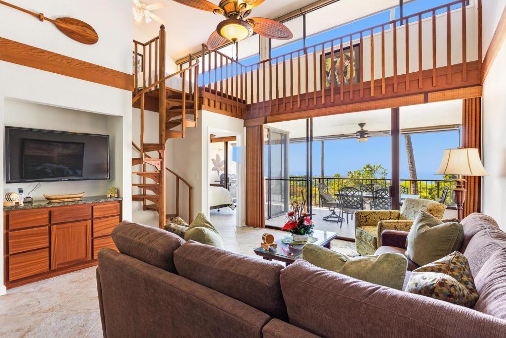 a living room with a couch and a tv at Country Club Villas 302 in Kailua-Kona