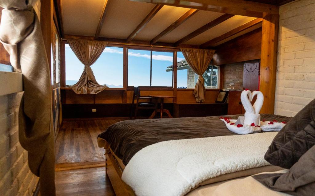 Un dormitorio con una cama con dos cisnes. en Centro Turístico Inti Wasi, en Saraguro