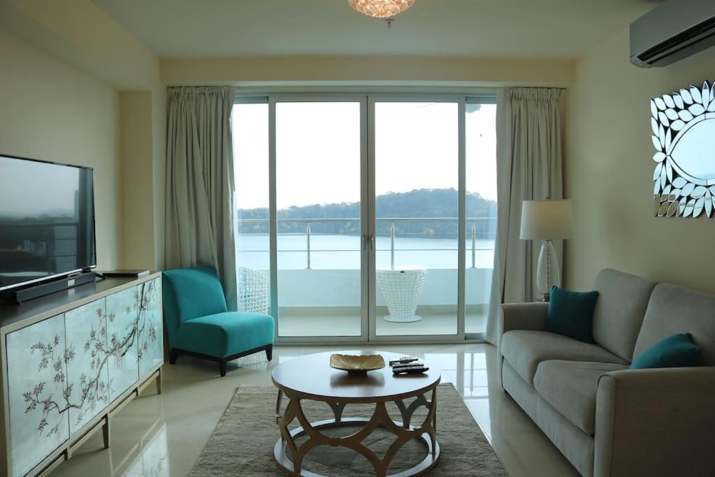 a living room with a couch and a tv and a table at 14B Luxury Oceanview Playa Bonita Resort Panama in ArraijÃ¡n