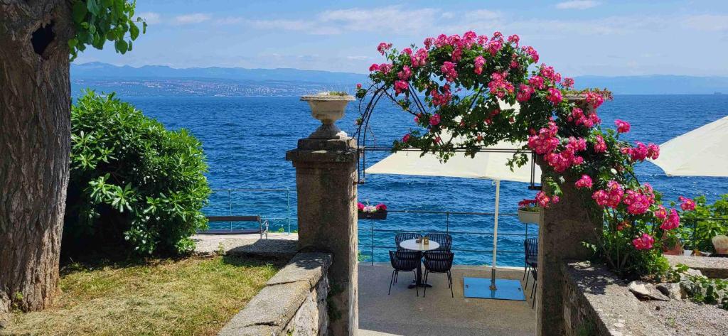 a view of the ocean from a garden with flowers at Apartment Vita in Lovran