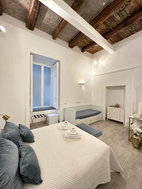 - une chambre avec un grand lit blanc et une fenêtre dans l'établissement MAISON MARINELLA, à Naples