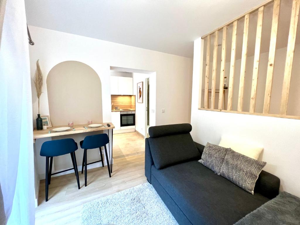 uma sala de estar com um sofá e uma mesa em Appartement ~ L'Amour à la Plage ~ à 15min de Lyon em Miribel