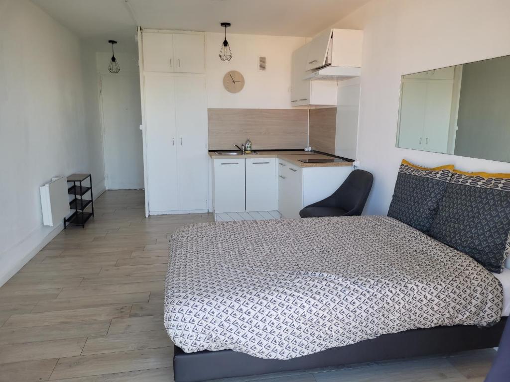 um pequeno quarto com uma cama e uma cozinha em logement vue sur mer em Canet-en-Roussillon