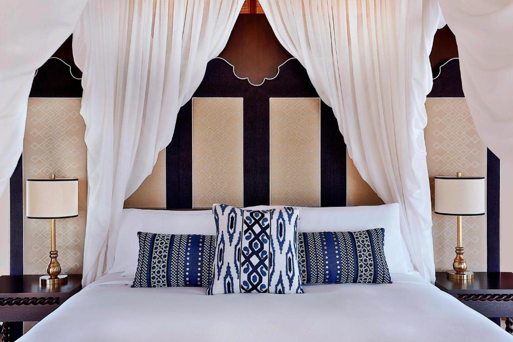 The Ritz-Carlton Ras Al Khaimah, Al Hamra Beach tesisinde bir odada yatak veya yataklar