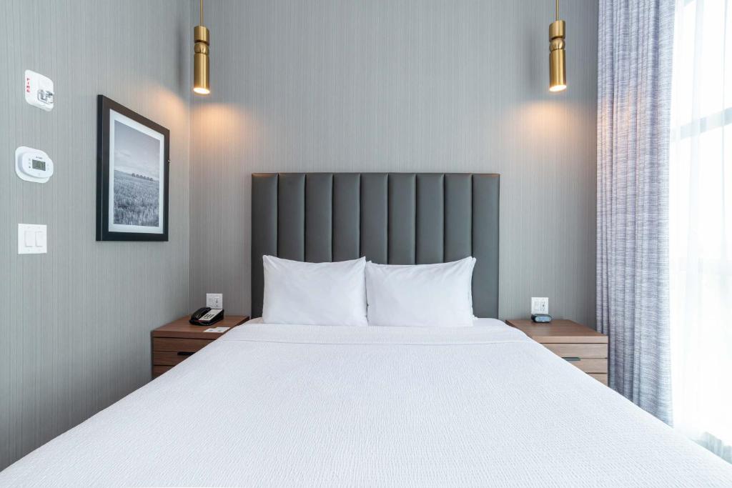 Postel nebo postele na pokoji v ubytování Sandman Signature Sherwood Park Hotel