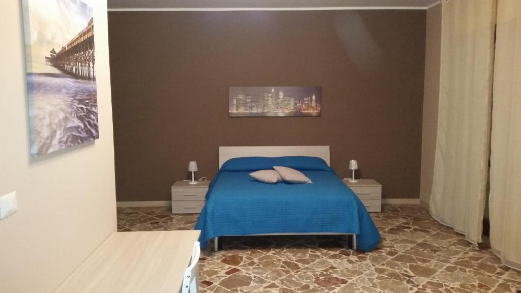 a bedroom with a blue bed with two pillows on it at B&B Don Pedro Riposto in Riposto