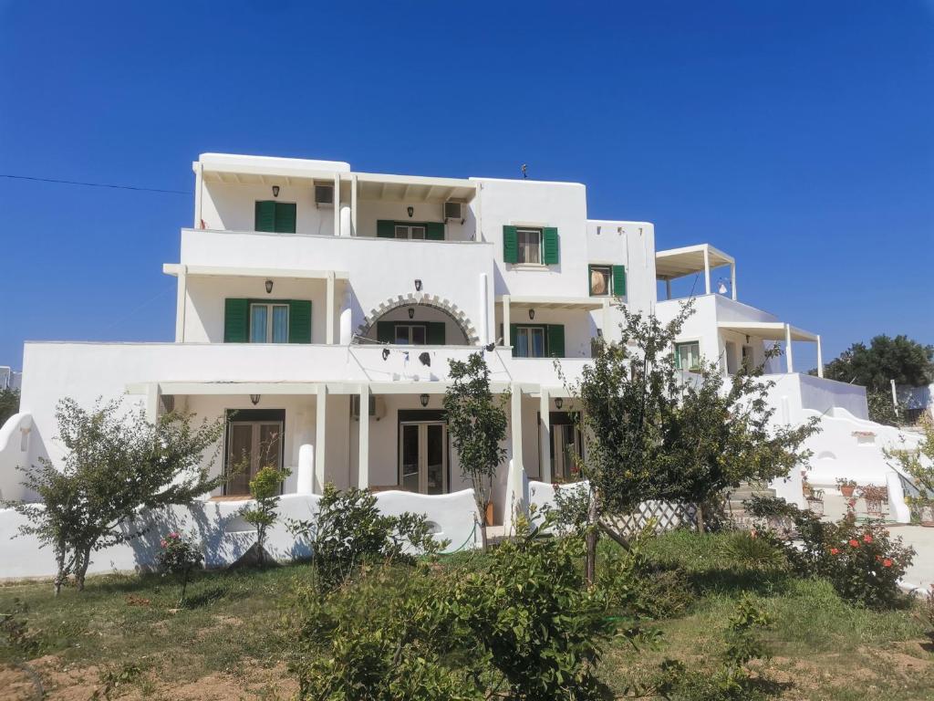 a large white building with trees in front of it at Studios Farma in Agia Anna Naxos