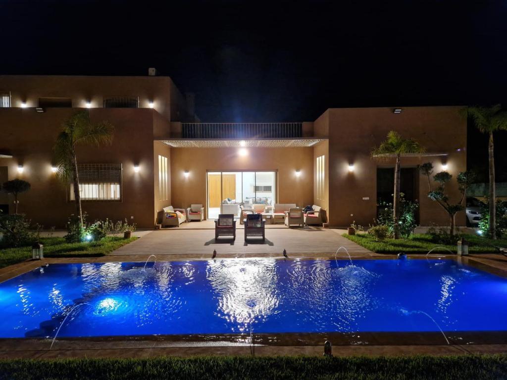a swimming pool in front of a house at night at Villa Treasure of Marrakech in Marrakech