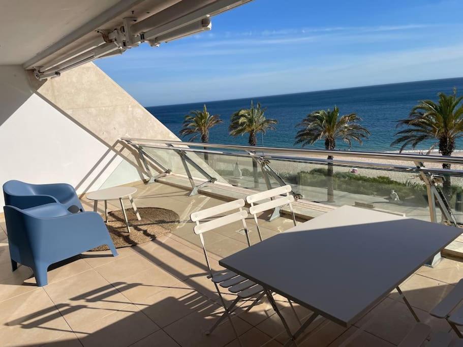 a balcony with a table and chairs and the ocean at Sesimbra Califórnia beach front in Sesimbra