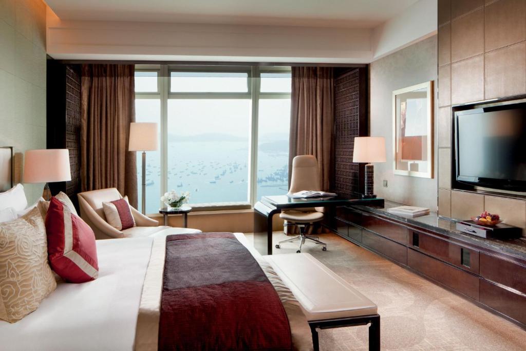 a hotel room with a large bed and a television at The Ritz-Carlton Hong Kong in Hong Kong