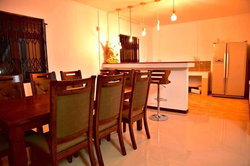 a kitchen with a table and chairs and a refrigerator at Villa Royal Bhudha in Goodlands