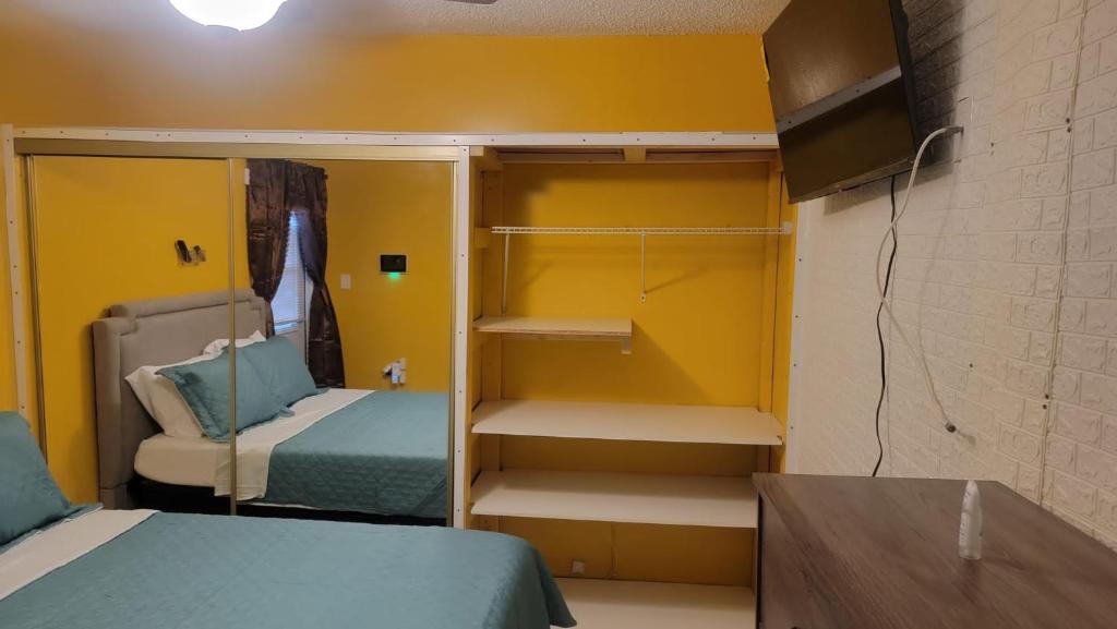 Habitación con 2 camas y pared amarilla. en Sunrise Efficiency, en Sunrise