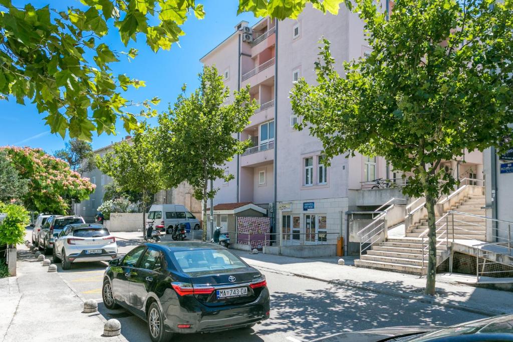 une voiture garée dans une rue en face d'un bâtiment dans l'établissement Apartments with WiFi Makarska - 20217, à Makarska