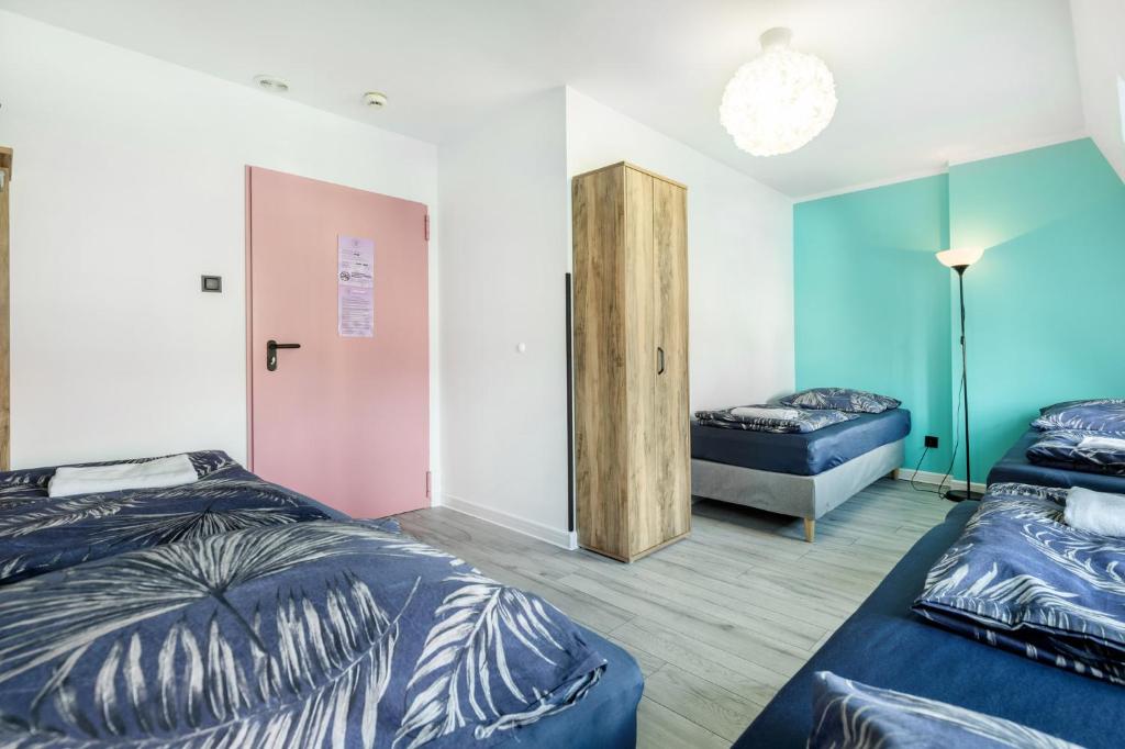 a room with two beds and a bedroom with a couch at VICE CITY Hostel in Wrocław